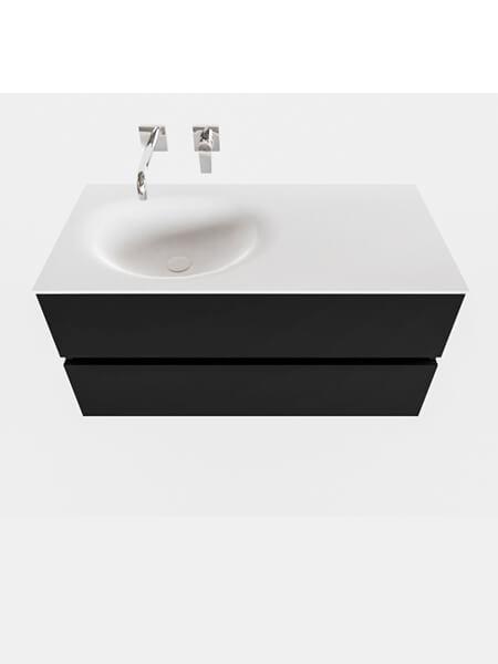 Mueble de baño 100 cm Vica negro mate con 2 cajones, lavabo de Solid surface seno izquierdo con 0 orificio(s) para el grifo. 2 Mueble de baño suspendido Vica 100 negro mate 2 cajones en acabado negro mate. Un mueble de baño de apertura suave por uñero con encimera para grifo empotrado y seno izquierda.