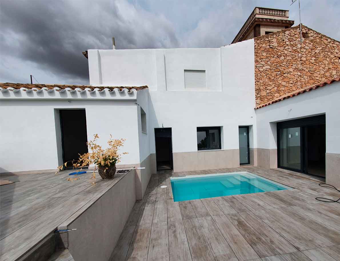 Piscina deslumbrante con revestimiento de porcelánico técnico en blanco