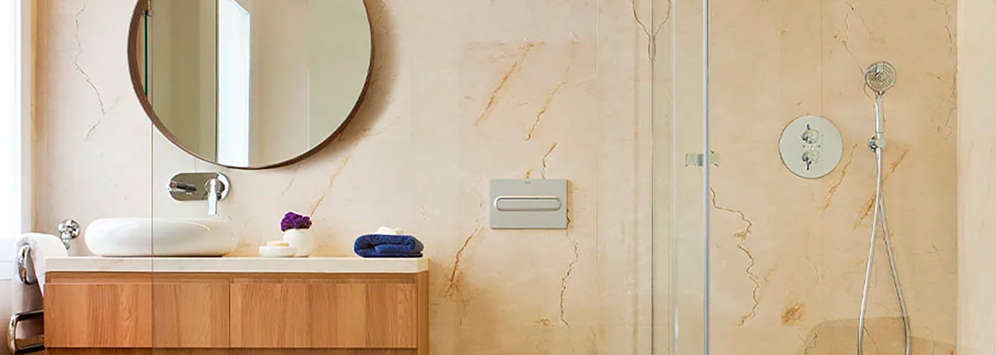 Baño contemporáneo con revestimiento de mármol y tocador de madera flotante.