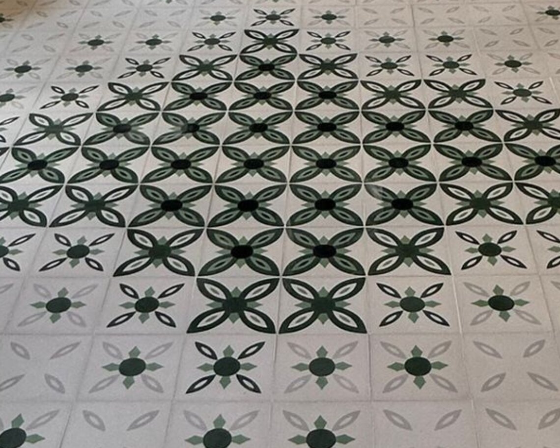 Piso de azulejos con patrones florales en tonos verdes y blancos, ideal para interiores modernos.
