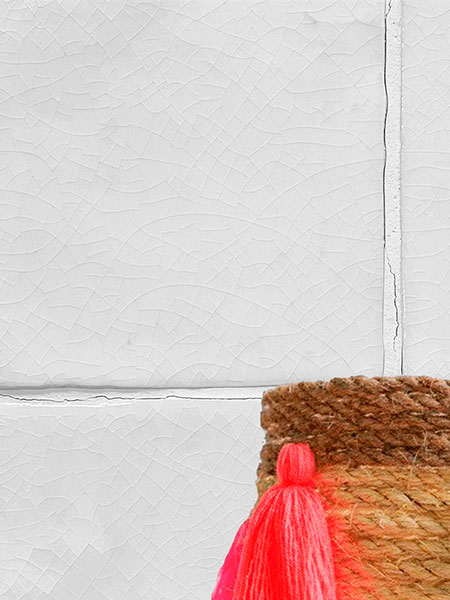 Revestimiento de pared con azulejos cerámicos artesanales blancos craquelados de 10x10 cm y decoración de cesto de mimbre