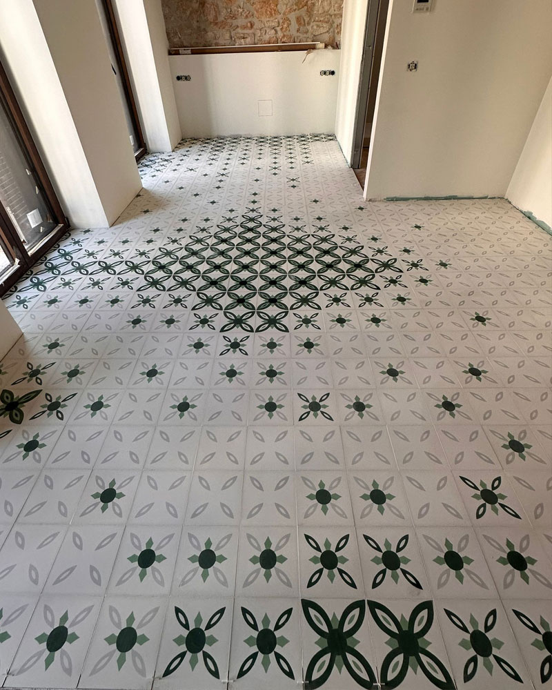 Artesano trabajando en la creación de una baldosa hidráulica personalizada.