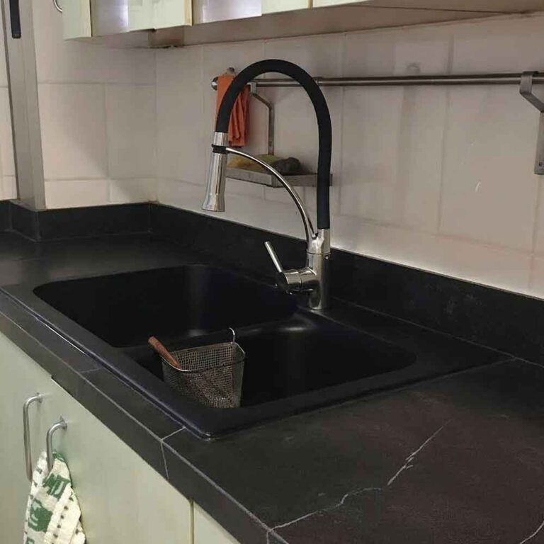 Primer plano de fregadero bajo encimera de cocina Concerto negra con grifo extraíble moderno