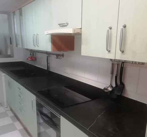 Encimera de cocina Concerto negra con acabado mate y vetas sutiles combinada con muebles blancos y vitrocerámica