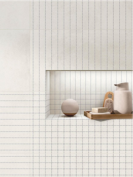 Detalle de baño contemporáneo con azulejos porcelánicos blancos de líneas geométricas y nicho decorativo integrado