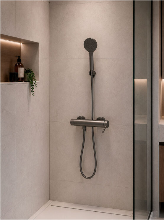 Grifo monomando de ducha en acabado negro mate con ducha de mano instalado en una ducha moderna con revestimiento porcelánico.