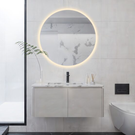 Espejo de baño redondo Rim con arenado perimetral y luz cálida ambiental sobre mueble de baño
