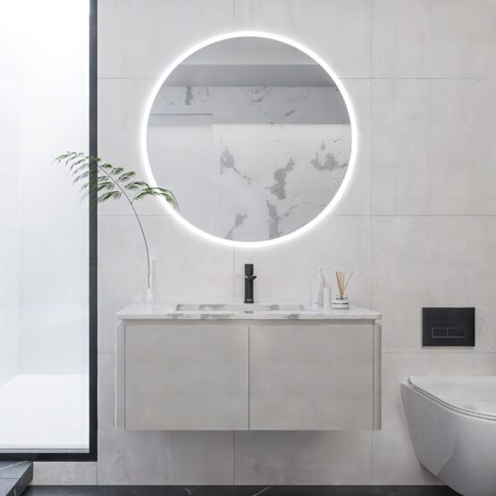 Espejo de baño redondo Rim con arenado perimetral y luz fría ambiental sobre mueble de baño