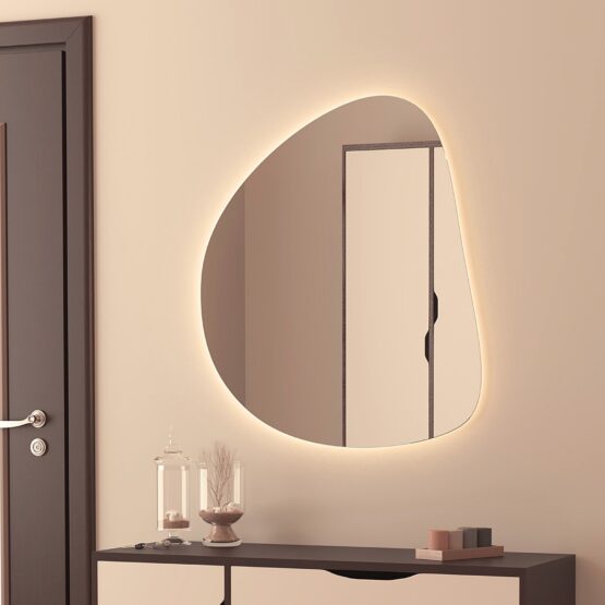 Espejo de bano Pedra de forma organica con luz ambiental encendida sobre un mueble
