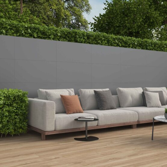 Terraza con muro revestido de porcelánico gris Manley 45x90 cm y suelo de madera