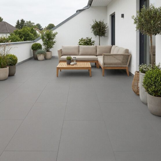 Terraza con pavimento porcelánico gris Manley 60x120 cm de gran formato y sofá de exterior
