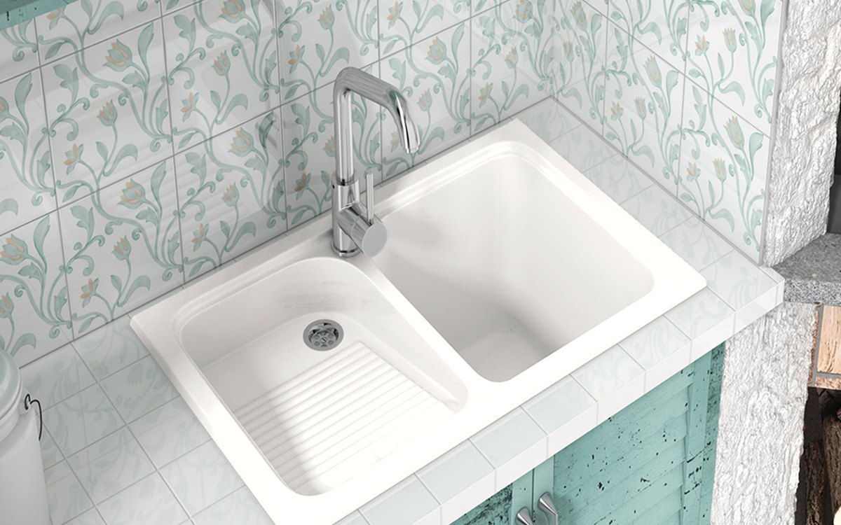 Fregadero de cuarzo blanco con escurridor en una cocina de azulejo